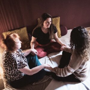 Lächelnde Teilnehmer:innen halten Händchen bei der Kuschelparty im KuschelRaum – Freude, Verbindung und achtsame Nähe erleben.