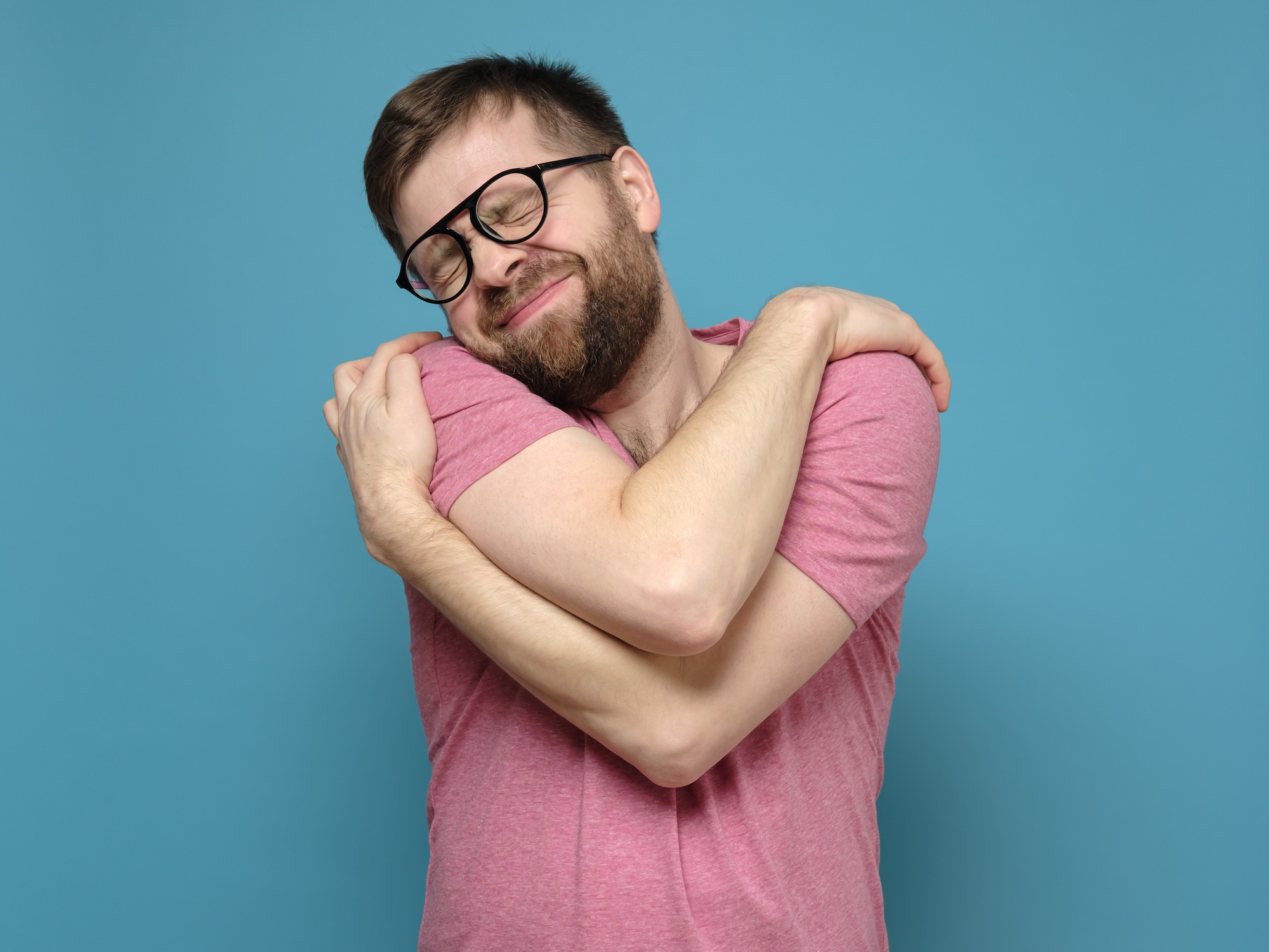 Mann umarmt sich selbst – nährende Selbstberührung als Ritual für mehr Selbstliebe