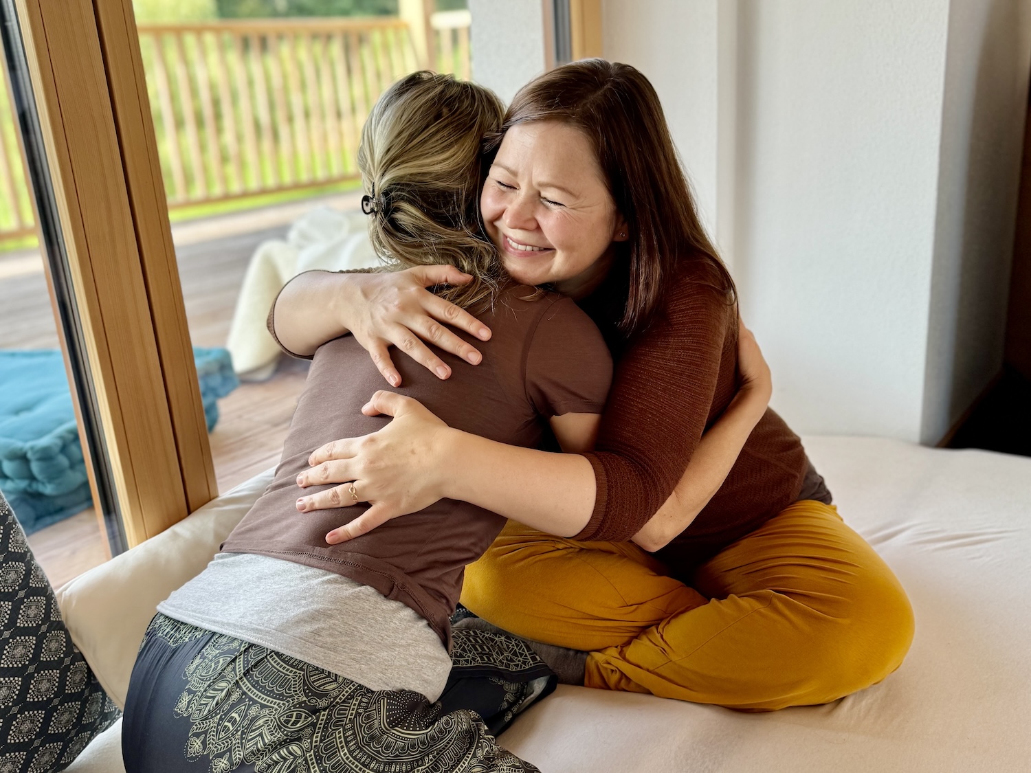 Liebevolle Begegnung zwischen Ausbilderin und Teilnehmerin. Ausbildung in Kuscheltherapie im KuschelRaum.