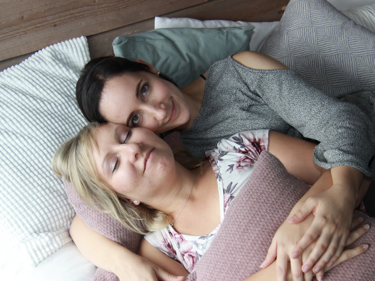 Kuscheltherapeutin schaut ganz entspannt udn relaxed, hält glückliche Klientin im Arm.